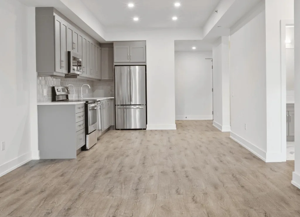 Modern apartment kitchen with grey cabinets and wood-look vinyl plank floors